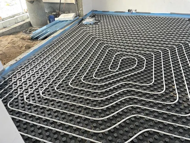 Spiral PEX underfloor heating loop installed on insulation panels on a Kuwait project