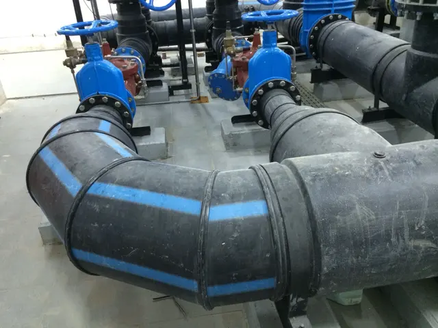 HDPE pipe bends and gate valves on supports in a Kuwait plant room