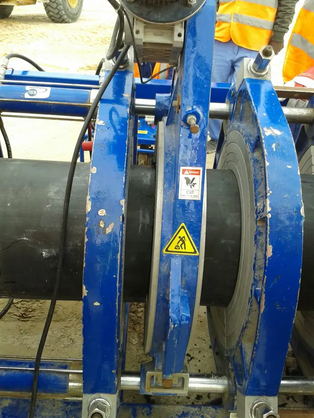 HDPE pipe being butt-fusion welded in a clamping machine on a Kuwait site