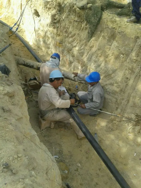 Workers jointing HDPE pipe inside an excavated trench in Kuwait